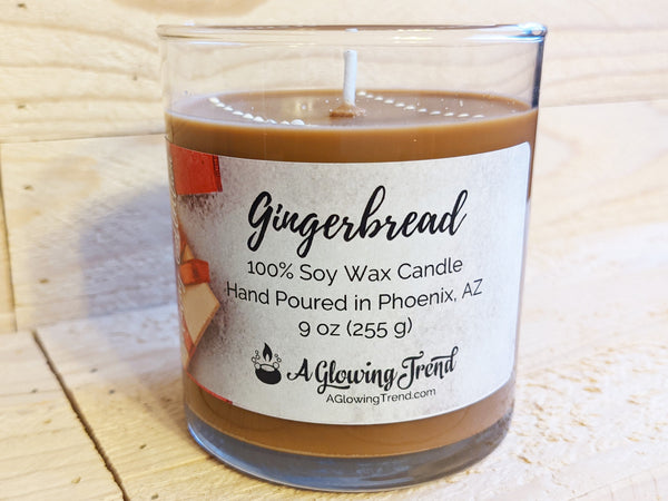 A 9 oz glass tumbler containing a brown Gingerbread scented soy candle topped with white wax drops by A Glowing Trend.