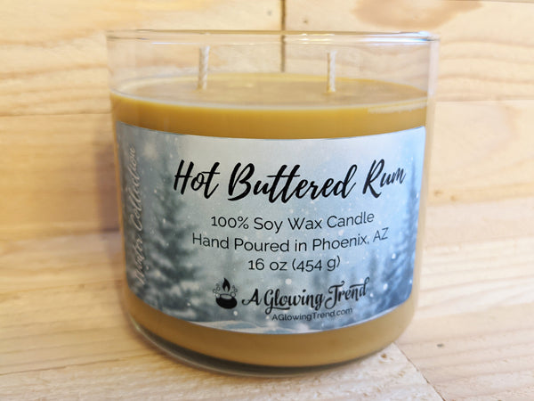 A 16 oz glass tumbler containing a light brown Hot Buttered Rum scented soy candle by A Glowing Trend
