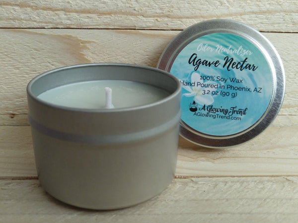 A 3.2 oz round tin containing a light green Odor Neutralizing Agave Nectar scented soy candle by A Glowing Trend.