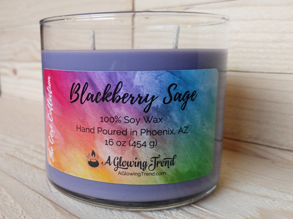 A 16 oz glass tumbler containing a purple Blackberry Sage scented soy candle by A Glowing Trend