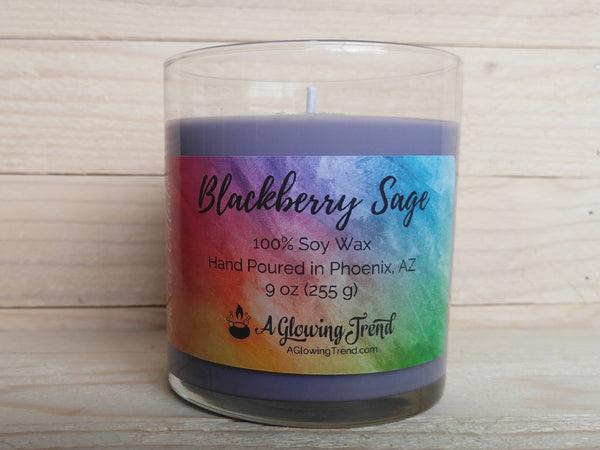 A 9 oz glass tumbler containing a purple Blackberry Sage scented soy candle by A Glowing Trend