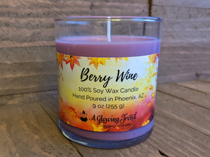 A 9 oz glass tumbler containing a purple Berry Wine scented soy candle by A Glowing Trend.