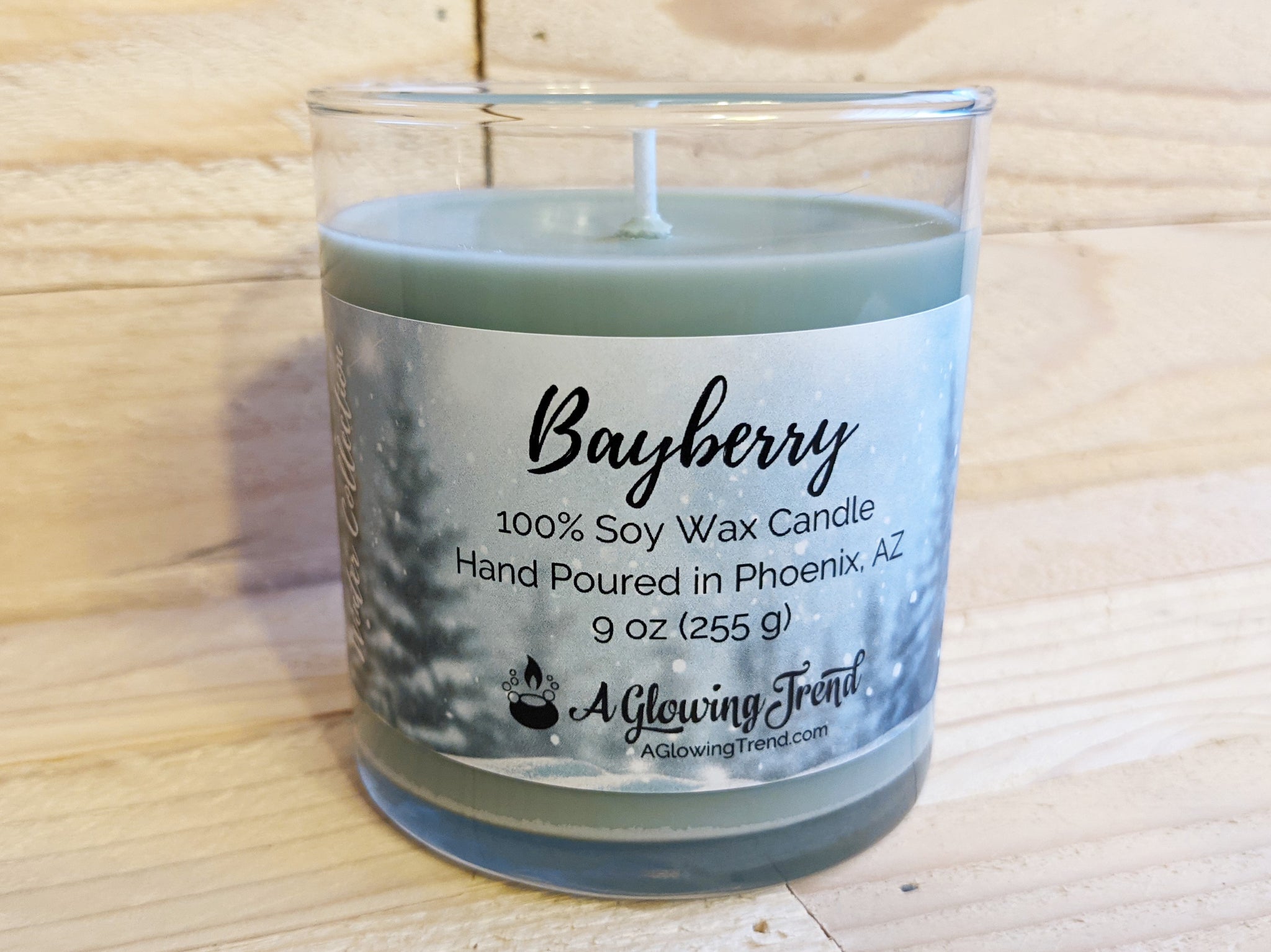 A 9 oz glass tumbler containing a green Bayberrry scented soy candle by A Glowing Trend