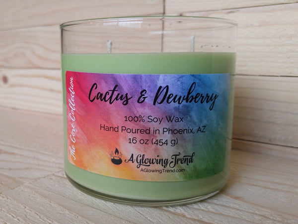 A 16 oz glass tumbler containing a light green Cactus and Dewberry scented soy candle by A Glowing Trend