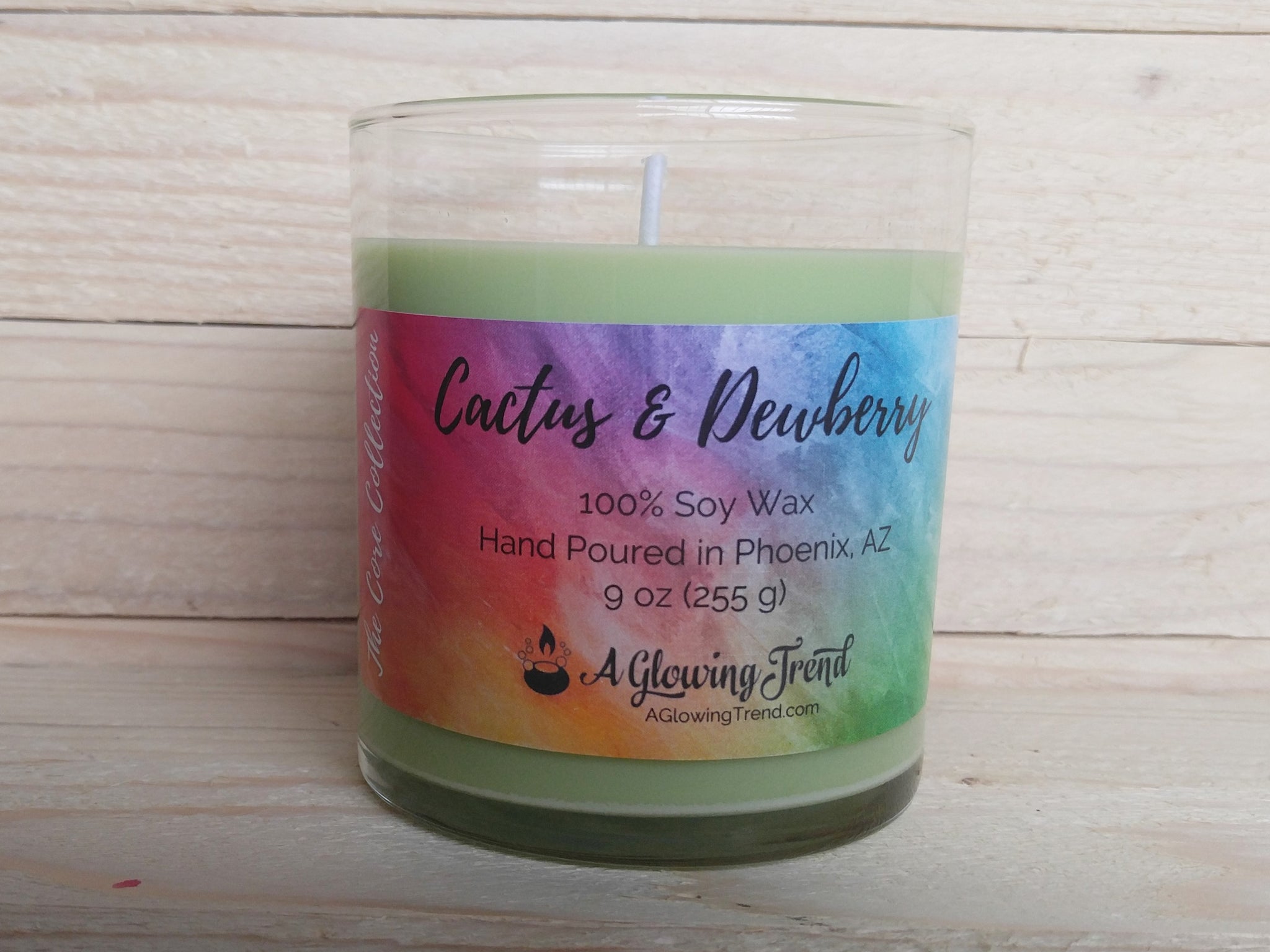 A 9 oz glass tumbler containing a light green Cactus and Dewberry scented soy candle by A Glowing Trend