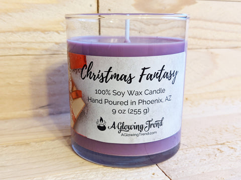A 9 oz glass tumbler containing a purple Christmas Fantasy scented soy candle topped with glitter by A Glowing Trend.