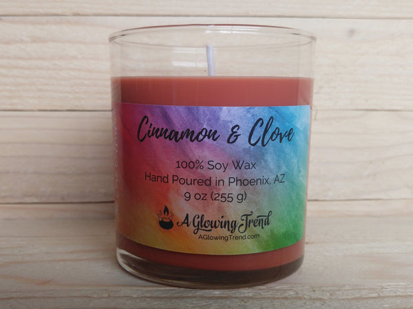 A 9 oz glass tumbler containing a reddish-brown Cinnamon and Clove scented soy candle by A Glowing Trend