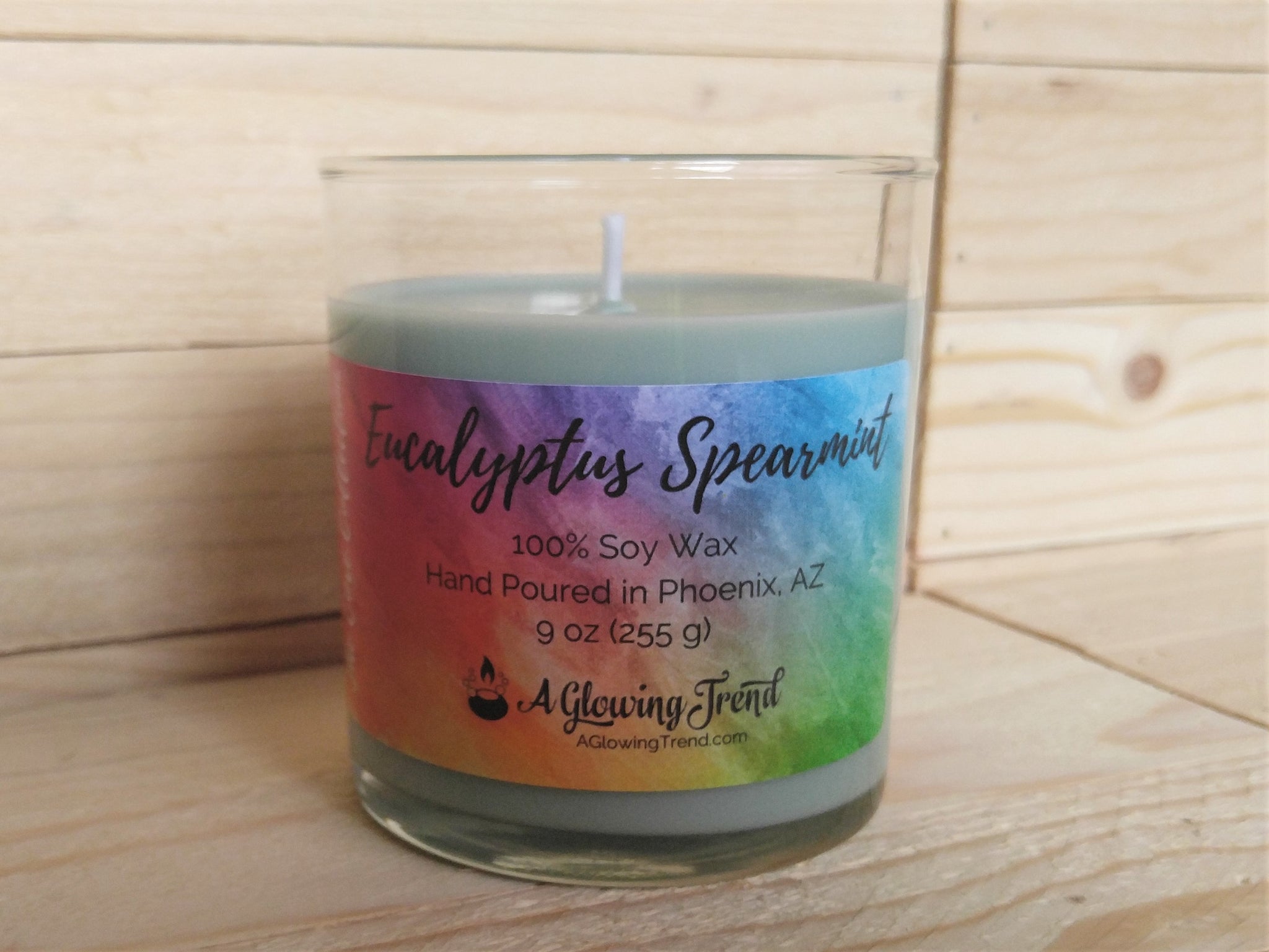 A 9 oz glass tumbler containing a light green Eucalyptus Spearmint scented soy candle by A Glowing Trend