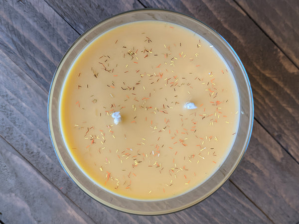 Close-up of yellow Fresh Fallen Leaves scented soy candle by A Glowing Trend showing the red, gold, and brown glitter.