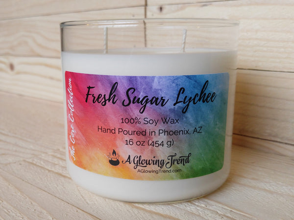 A 16 oz glass tumbler containing a white Fresh Sugar Lychee scented soy candle by A Glowing Trend