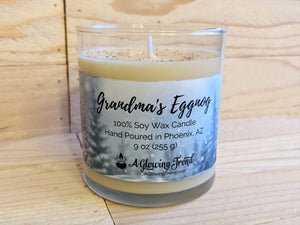 A 9 oz glass tumbler containing a light yellow Grandma's Eggnog scented soy candle topped with nutmeg by A Glowing Trend.
