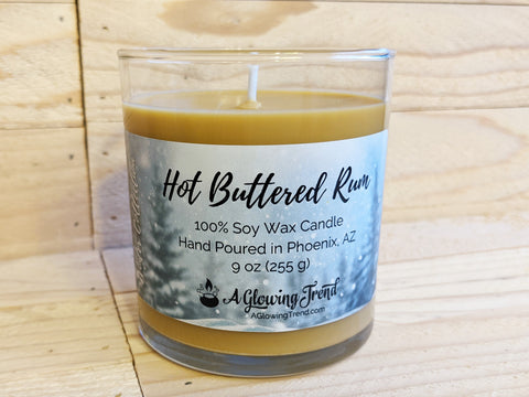 A 9 oz glass tumbler containing a light brown Hot Buttered Rum scented soy candle by A Glowing Trend