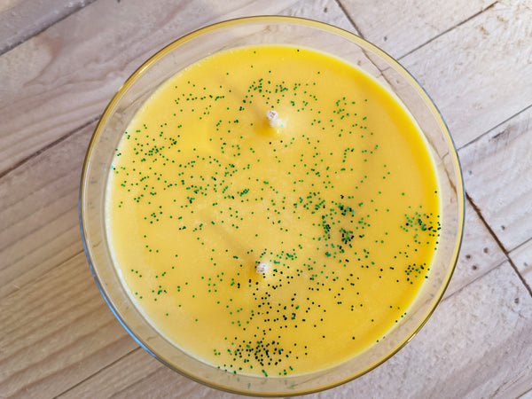 Close-up of yellow Home for the Holidays scented soy candle by A Glowing Trend showing glitter.