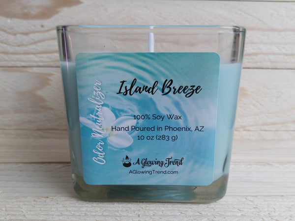 A 10 oz glass square containing a light blue Odor Neutralizing Island Breeze scented soy candle by A Glowing Trend.