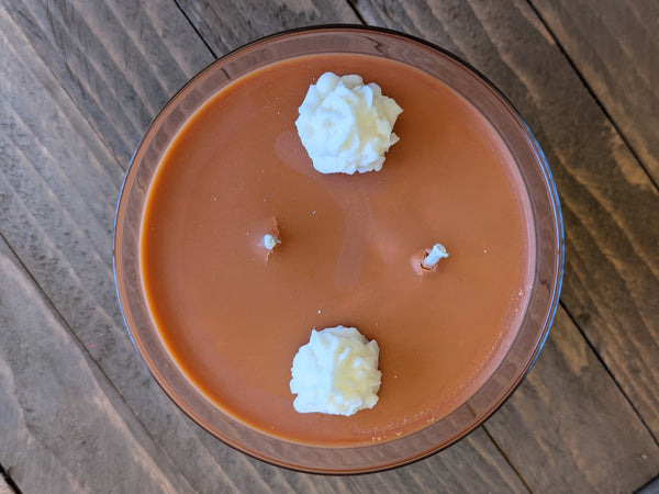 Close-up of orange Pumpkin Pie scented soy candle by A Glowing Trend showing white wax whipped cream dollops.