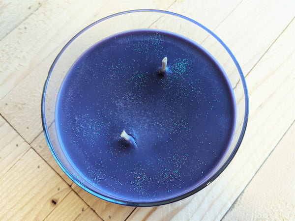 Close-up of purple Sugar Plum scented soy candle by A Glowing Trend showing glitter.