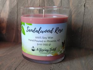 A 9 oz glass tumbler containing a dusty pink Sandalwood Rose scented soy candle by A Glowing Trend.