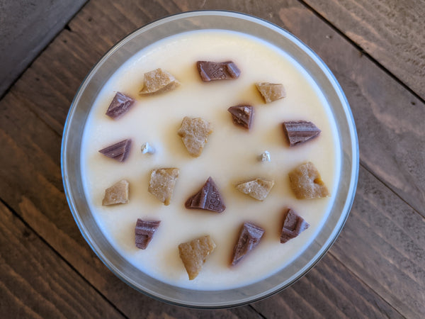 Close-up of white S'mores scented soy candle by A Glowing Trend showing the wax graham cracker and chocolate bits.