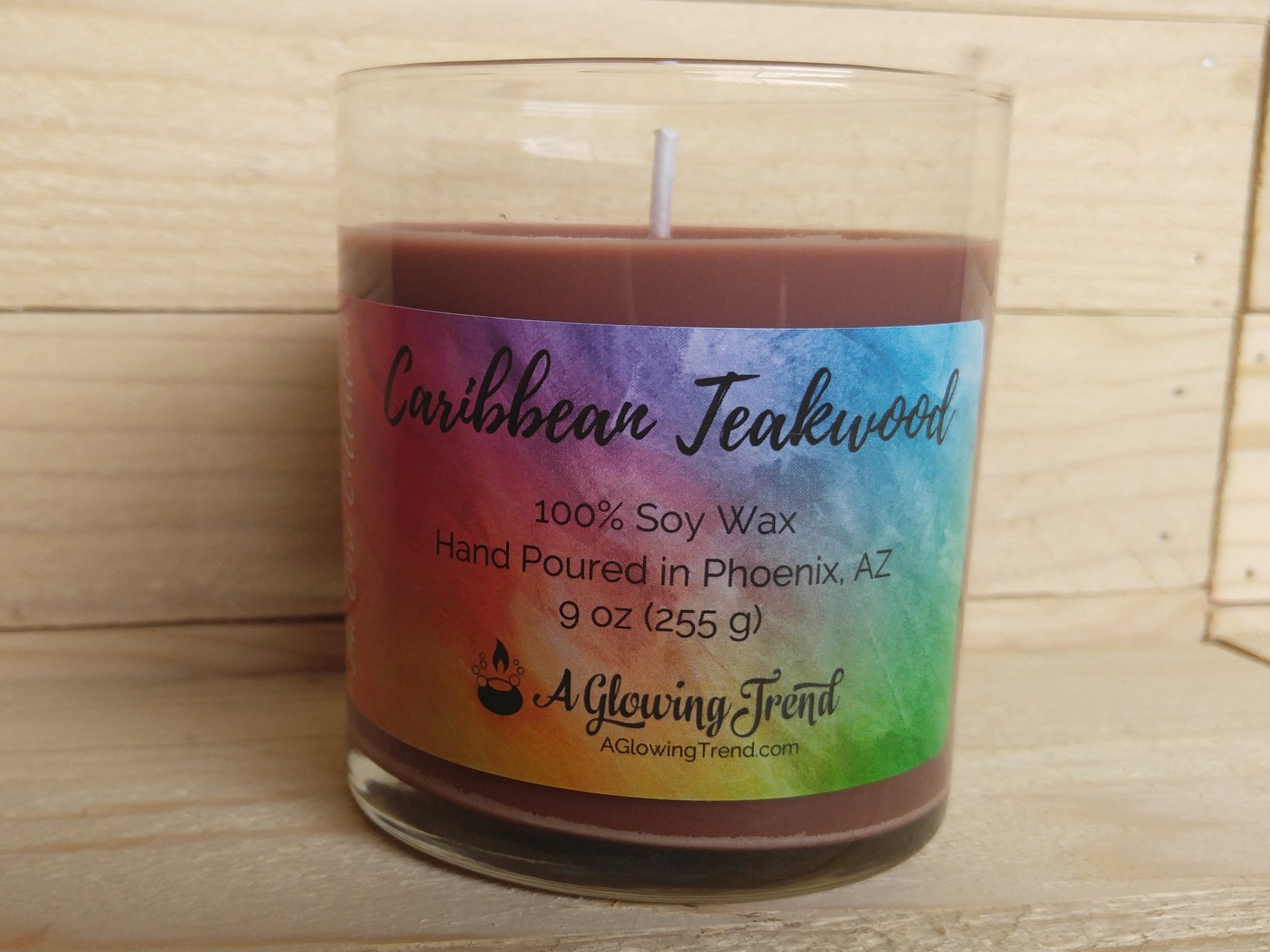 A 9 oz glass tumbler containing a brown Caribbean Teakwood scented soy candle by A Glowing Trend