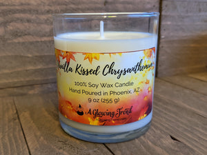 A 9 oz glass tumbler containing a white Vanilla Kissed Chrysanthemum scented soy candle by A Glowing Trend.