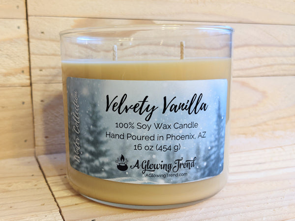 A 16 oz glass tumbler containing a light yellow Velvety Vanilla scented soy candle by A Glowing Trend