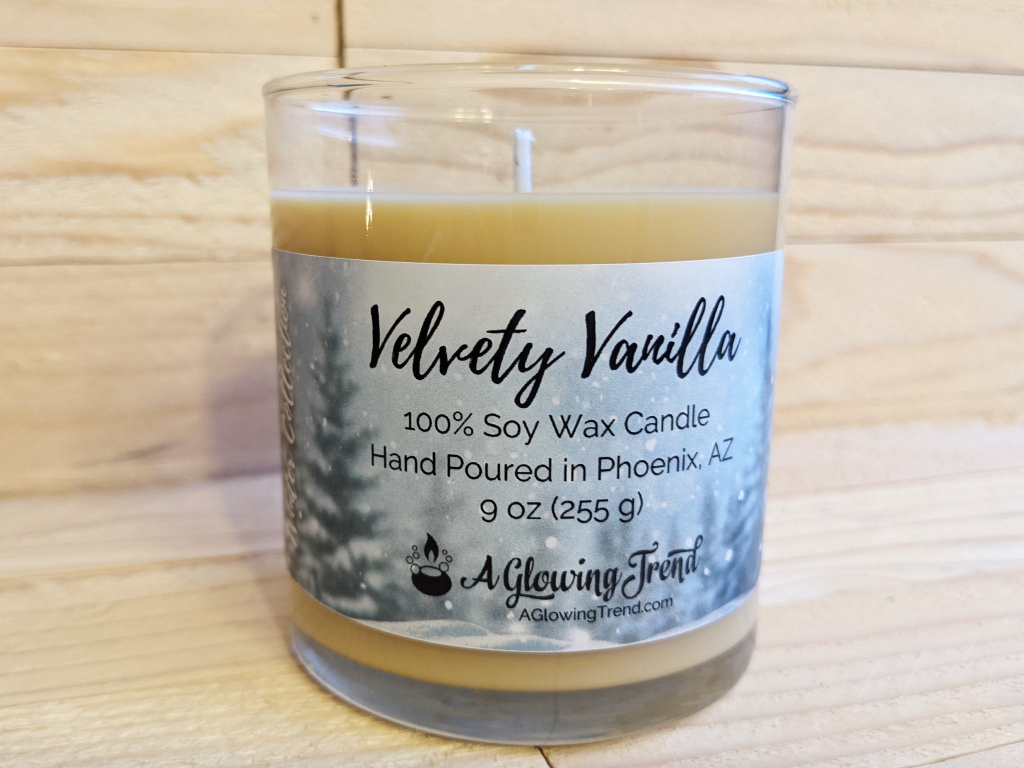 A 9 oz glass tumbler containing a light yellow Velvety Vanilla scented soy candle by A Glowing Trend