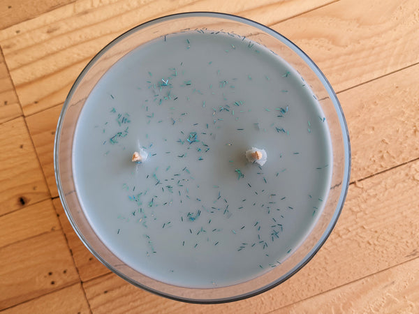 Close-up of blue Winter Wonderland scented soy candle by A Glowing Trend showing glitter.